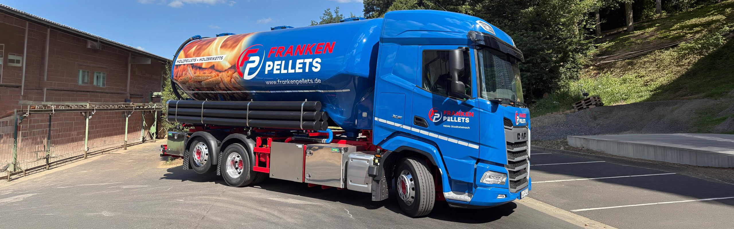Blauer LKW von Franken Pellets steht auf einem leeren Parkplatz.